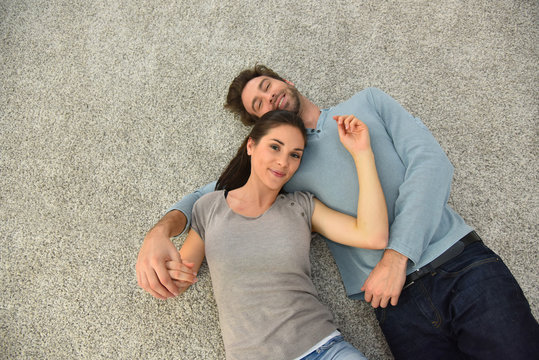 Upper view of couple laying on carpet