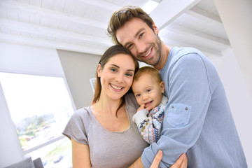 Obraz premium Portrait of happy parents holding baby girl