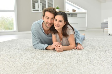 Couple laying on carpet in living room