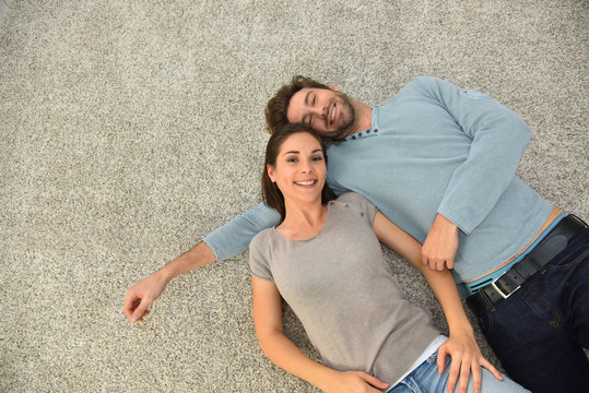 Upper view of couple laying on carpet