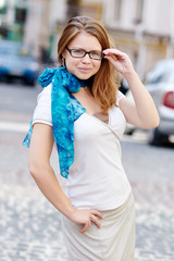 pretty young woman with glasses against a street background