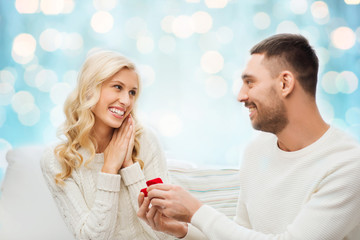 happy man giving engagement ring to woman