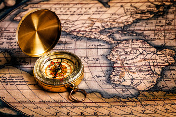 Old vintage golden compass on ancient map