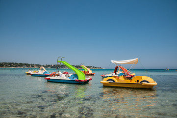 Beach in the clear sea of Sicily with a pedalo for fun people 