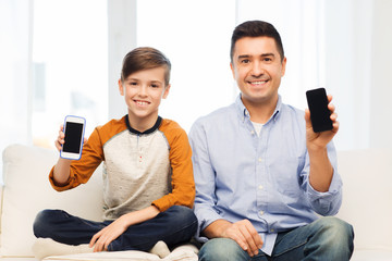 happy father and son with smartphones at home