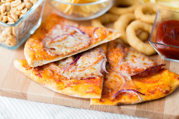close up of pizza and other snacks on wooden table