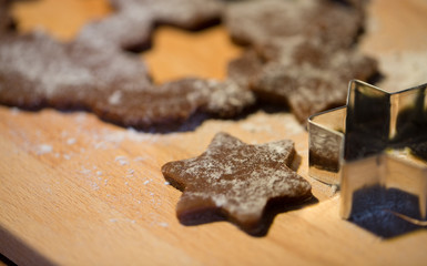 close up of ginger dough, molds and flour on board