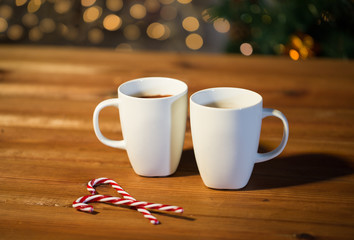 christmas candy canes and cups on wooden table