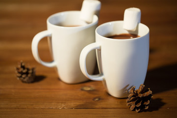 cups of hot chocolate with marshmallow on wood