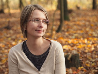 Happy young woman in autumn forest