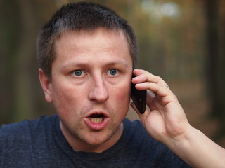 Angry surprised man with a smartphone.