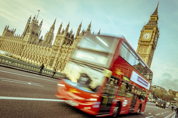 Obraz premium Double decker bus in motion, Big Ben and Winchester parliament