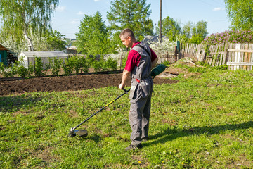 Man mowing grass with a trimmer