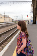 Young girl on train station platform with bags