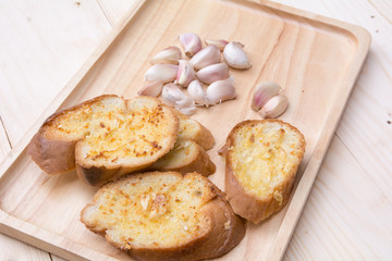 crispy garlic bread in wood tray