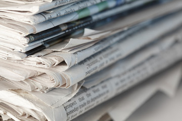 A stack of newspapers. Focus on near edge of stack.