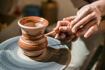 Fototapeta na wymiar Master potter teaches the child how to make a pitcher on a pottery wheel