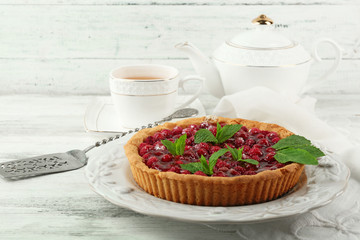 Tart with raspberries and tasty tea, on color  wooden background