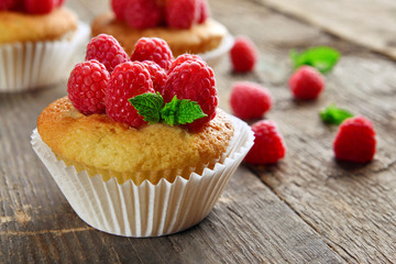 Delicious cupcakes with berries and fresh mint on wooden table close up