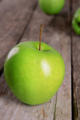 Ripe green apple on wooden table close up