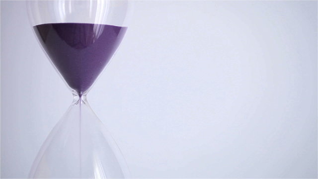 Sand flowing through an hourglass - real time, copy space