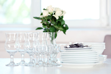 Clean plates, glasses and cutlery on white table