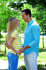 Young pregnant woman with husband in park