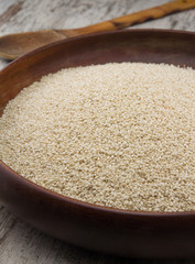 Sesame seeds in a wooden plate over wooden background