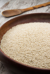 Sesame seeds in a wooden plate over wooden background