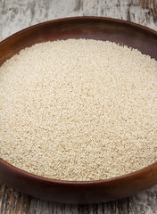 Sesame seeds in a wooden plate over wooden background