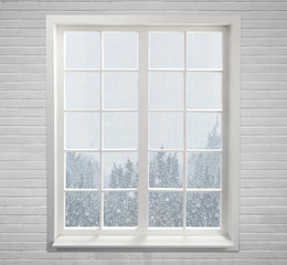 Modern residential window with snow and trees
