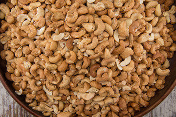 Raw cashews close-up in wooden bowl