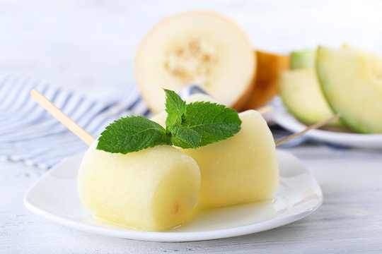 Melon ice lolly on wooden table, closeup
