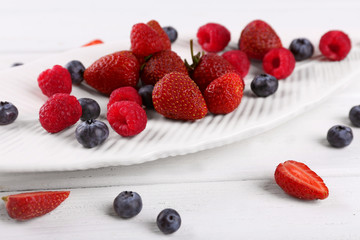Tasty ripe berries on wooden table close up