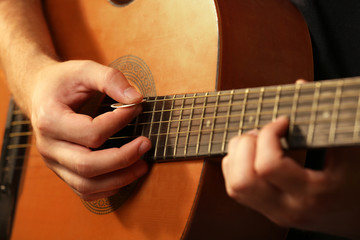 Fototapeta premium Young musician playing acoustic guitar close up