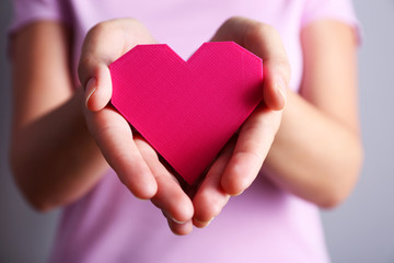 Obraz premium Closeup of plastic puzzle heart in female hands