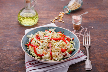 Salad from cabbage with red pepper and pine nuts.