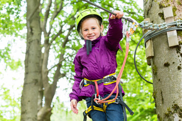 Mädchen klettert im Hochseilgarten