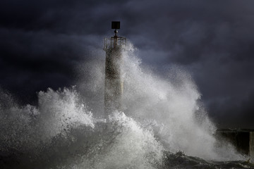 Fototapeta na wymiar Stormy waves over lighthouse