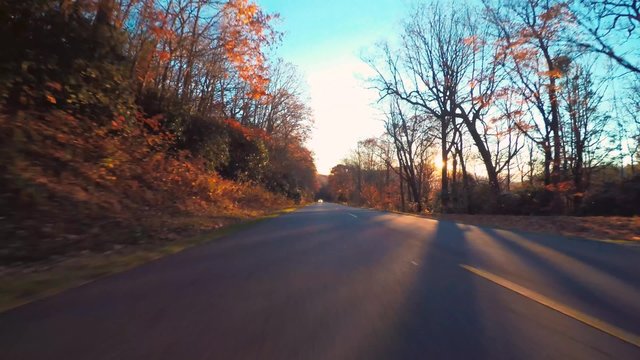 Autumn driving shot of the Blue Ridge Parkway through North Carolina at sunset