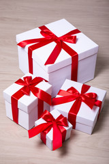 present boxes with red ribbon on wooden background
