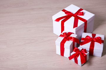 Christmas concept -present boxes with red ribbon on wooden backg