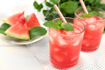 Cold watermelon desserts and drinks in glasses, on wooden table background
