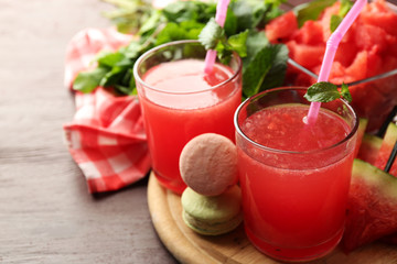 Cold watermelon drinks in glasses, on wooden table background