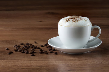 Coffee cup and beans on wooden texture