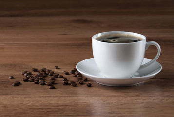 Coffee cup and beans on wooden texture