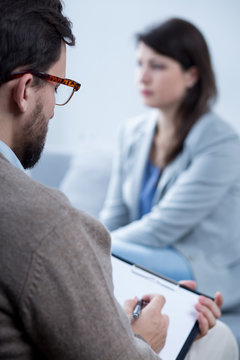 Male psychotherapist talking with woman