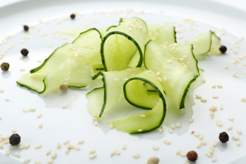 Sliced cucumbers dish on white plate in the restaurant, close up