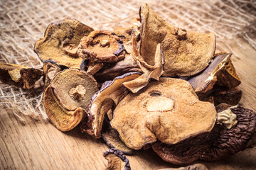 Dry mushrooms on wooden rustic table.