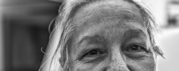 Closeup of aged smiling senior woman, mother, grandma in black and white. B/W photography, portrait middleaged female person looking healthy, perfect for lifestyle, health blog, business website